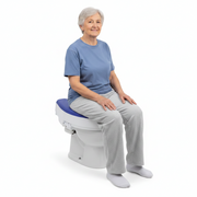 Raised toilet seat shown with a person seated on it for scale