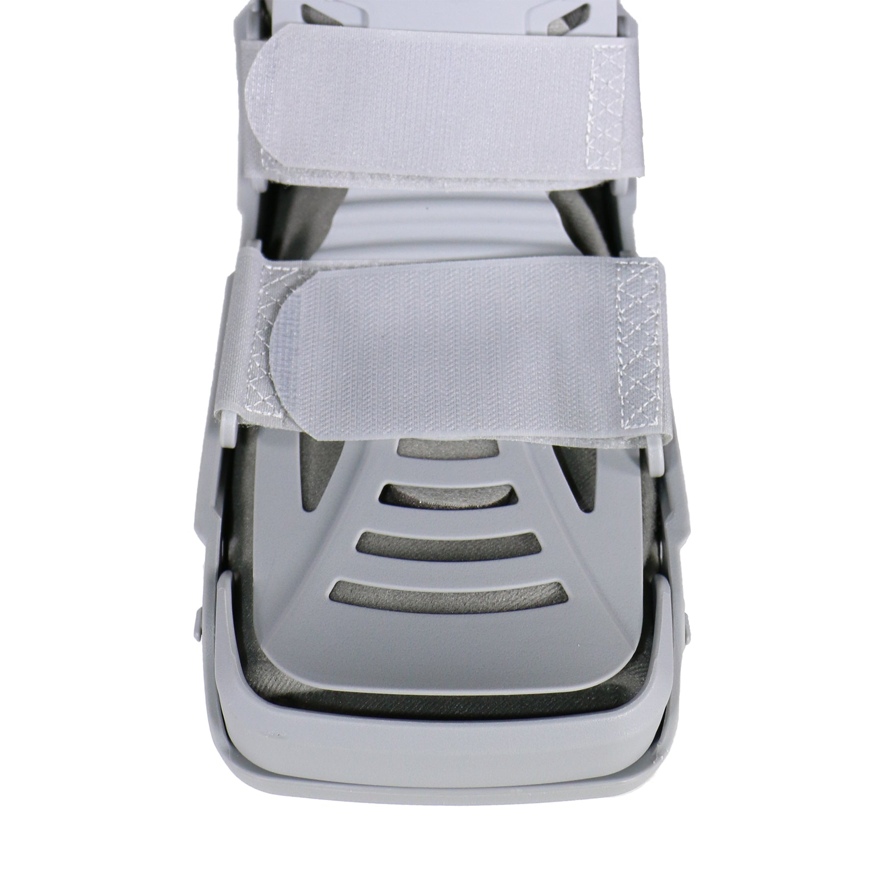 Top-down view of grey air CAM walking boot showing open toe design, vented grey footplate with contoured channels, padded instep strap, and rigid shell frame — detail view of breathable foot platform