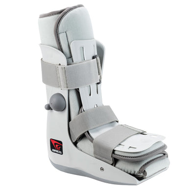 Breg Genesis Mid-Calf Walking Boot in white and grey – compact low-cut ankle walker with plush foam collar, side air pump, two wide velcro straps, and cushioned footbed, angled side view on white background
