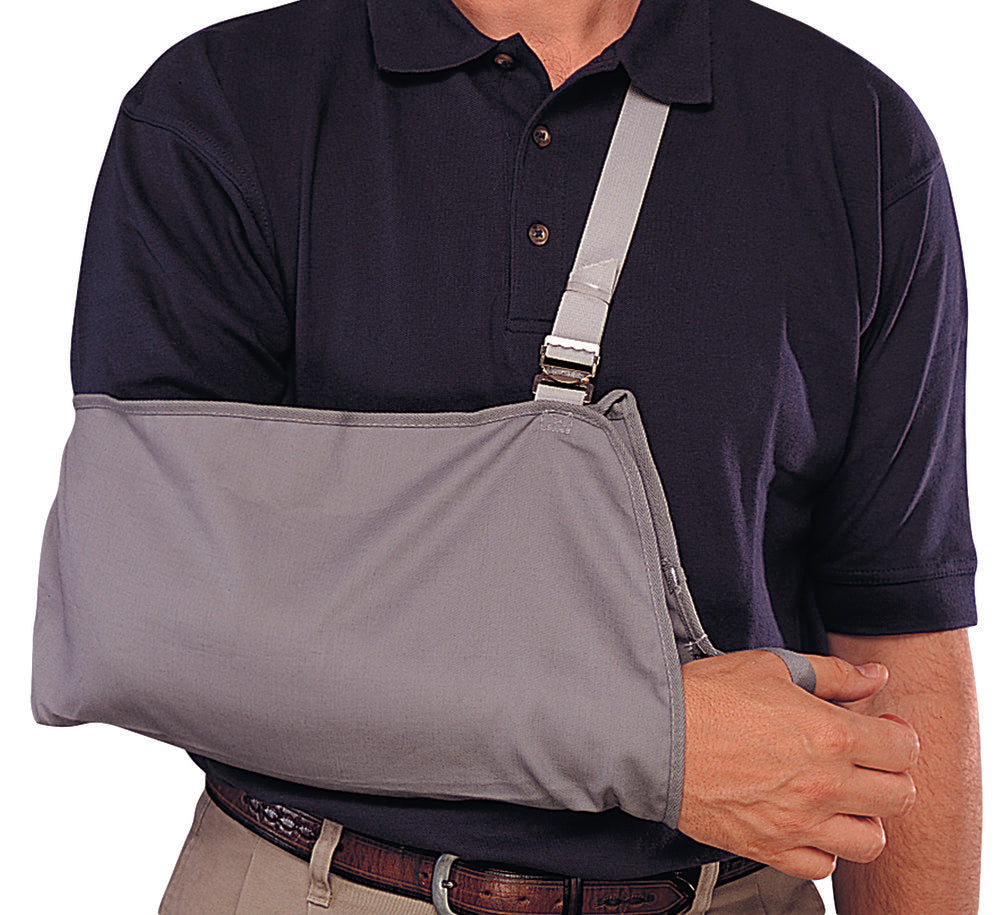 Adult grey cradle arm sling with adjustable shoulder strap worn by man in navy polo shirt – Champion – Must