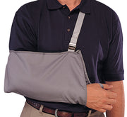 Adult grey cradle arm sling with adjustable shoulder strap worn by man in navy polo shirt – Champion – Must