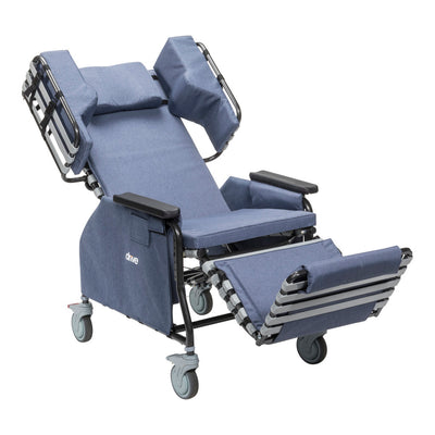 Drive tilt-and-recline chair with casters shown fully reclined, extended leg rest, padded armrests, headrest, and blue upholstery — available at Must in Metro Vancouver