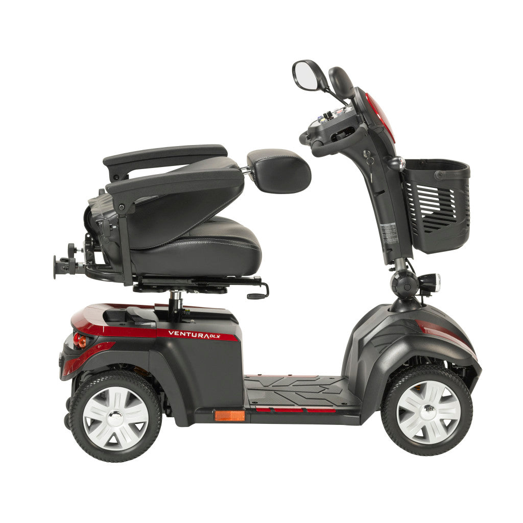 Side profile of Drive Ventura DLX 4-wheel mobility scooter in red and black showing swivel captain seat, armrests, tiller, front basket, headlight, and spoke wheels
