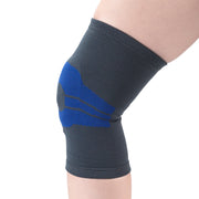 Grey and blue knitted knee compression sleeve with blue gel pad and patella support panel worn on leg — side view showing anatomically contoured fit, targeted knee compression, and breathable elastic fabric