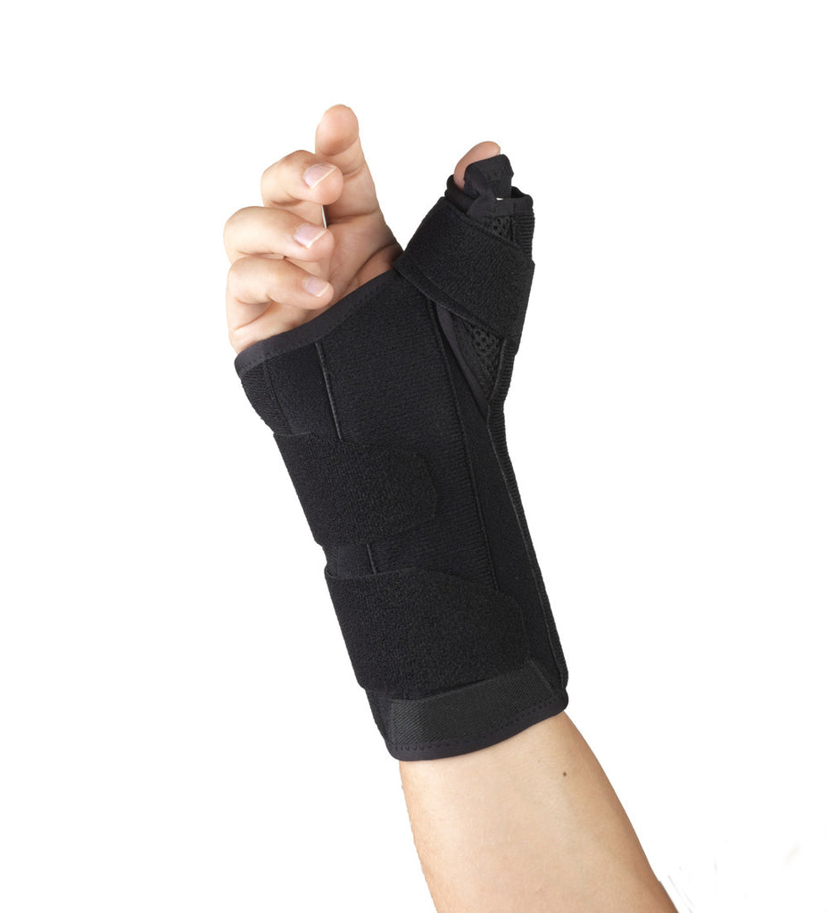 OTC 2387 thumb spica wrist brace worn on right hand showing thumb spica extension, wrap-around velcro straps, and soft fabric construction on white background
