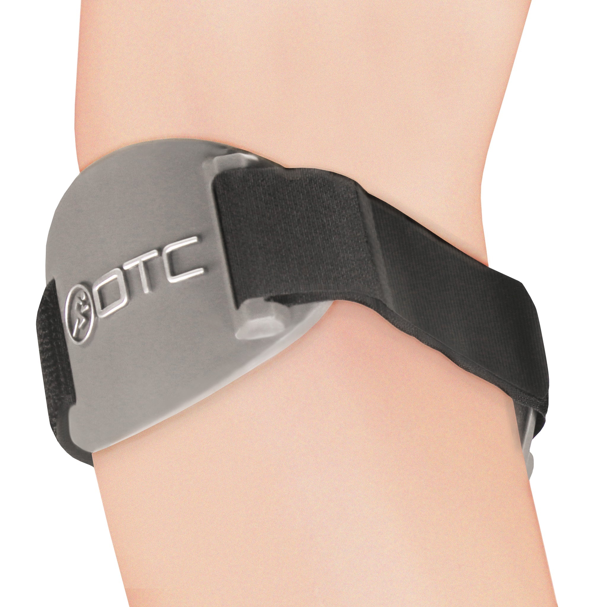 3-quarter angle side view of OTC 2421 tennis elbow brace on forearm showing grey oval pressure pad with OTC logo, diagonal black elastic strap, and strap channel guide hardware